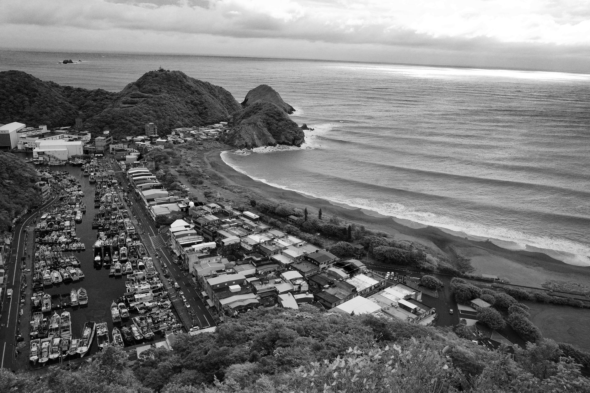 Une vue aérienne captivante en noir et blanc de la côte du comté de Yilan, Taiwan, présentant une marina et le paysage environnant.