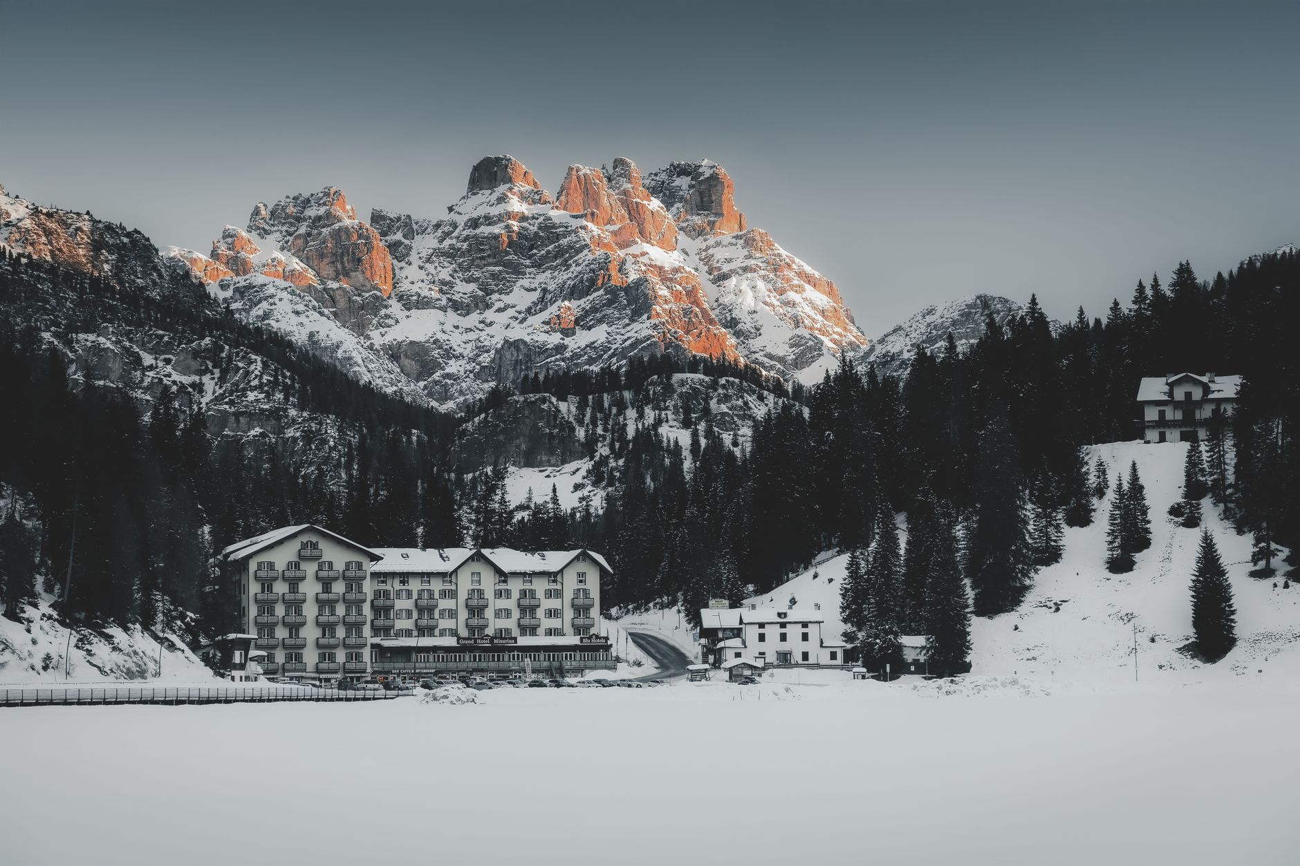 Magnifique village alpin enneigé au pied de montagnes majestueuses en hiver.