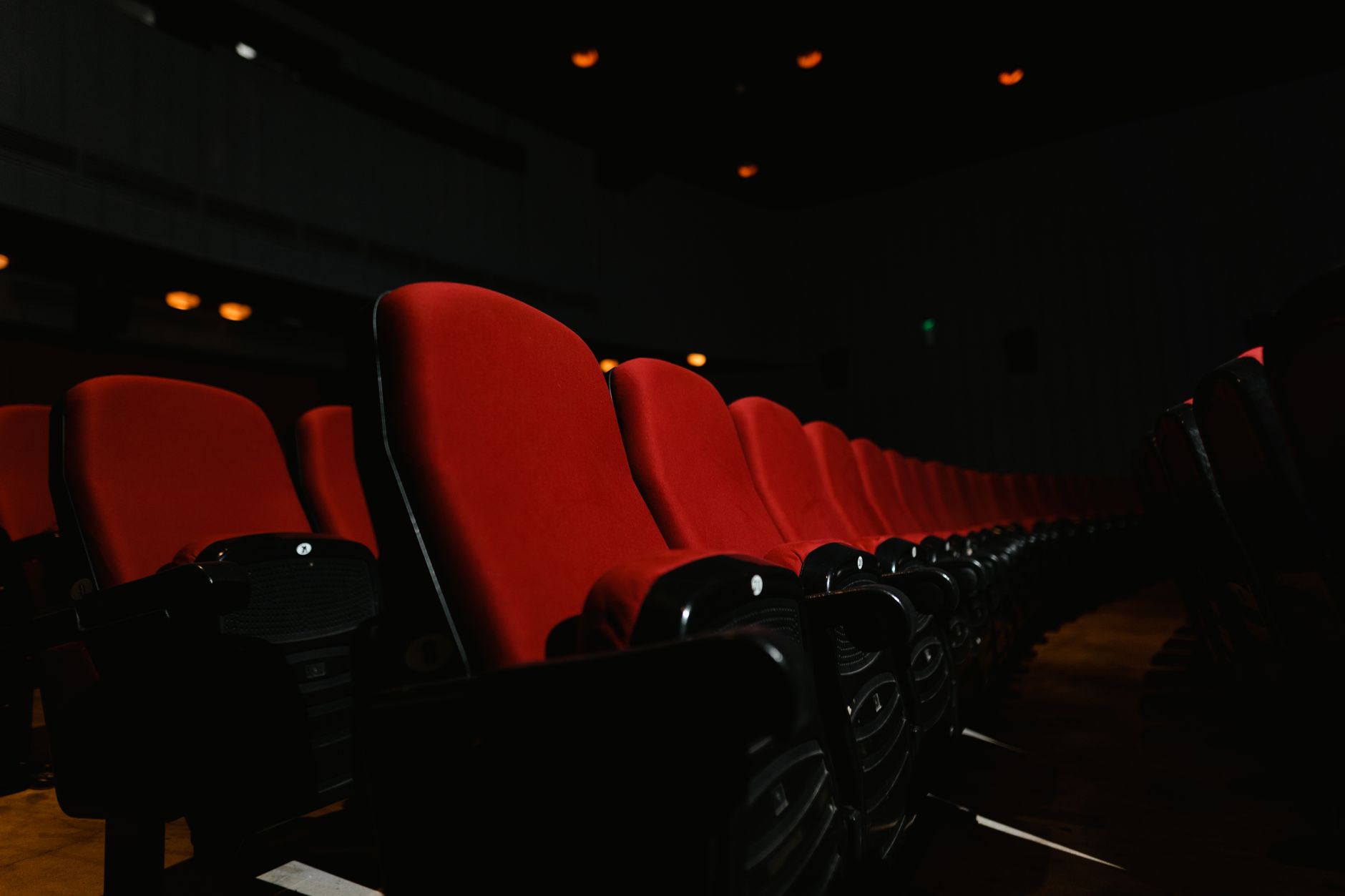 Rangée de fauteuils rouges vides dans une salle de cinéma